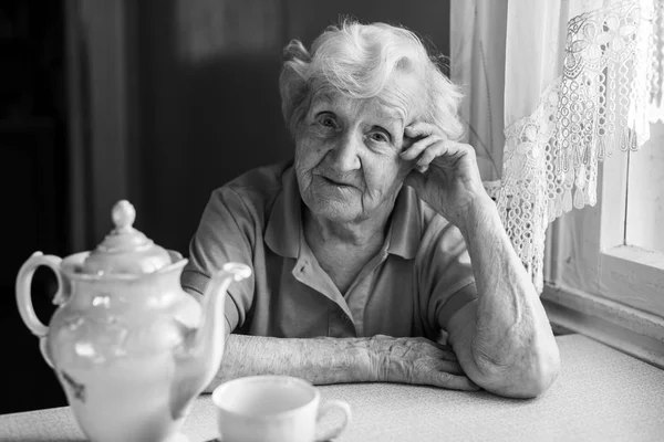 Yaşlı kadının evinde siyah beyaz portre. 