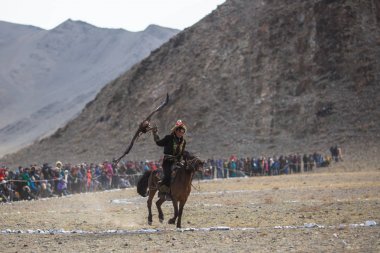 Olgiy, Moğolistan - Eyl 30, 2017: Altın Kartal avcısıyla kuşları Berkutchi Batı Moğolistan ile yıllık Ulusal yarışma sırasında kolunda altın kartal, geleneksel kıyafetleri,.