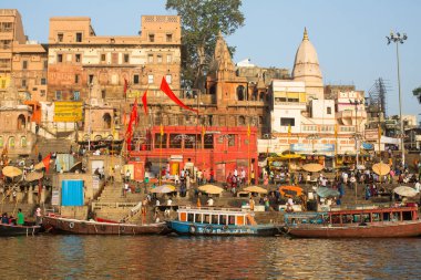 Varanasi, Hindistan - 26 Mar 2018: Bir tekne görünümünden suda Varanasi kıyı boyunca Ganj Nehri üzerinde süzülüyor. Efsaneye göre şehrin yaklaşık 5000 yıl önce Tanrı Shiva tarafından kuruldu.