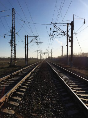 Sanayi bölgesinde demiryolu rayları ve elektrik nakil hatları.