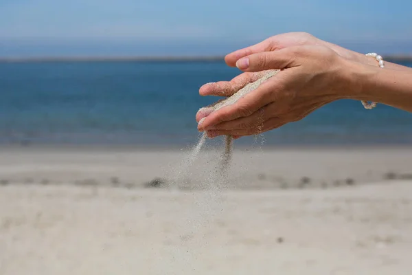 Areia Derrama Através Dos Dedos Contra Mar — Fotografia de Stock