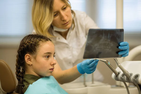 Odontóloga Muestra Una Radiografía Una Niña Sentada Una Silla Dental —  Fotos de Stock