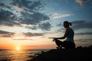 İnanılmaz gün batımında yoga yapan kadının silueti.. 