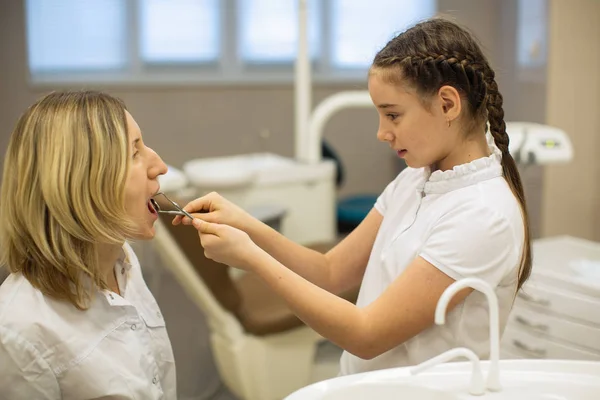 在诊所的牙科椅子上 小女孩正在做一个有趣的女牙医牙齿检查 — 图库照片