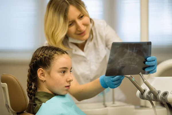 Mujer Dentista Muestra Una Radiografía Una Pequeña Paciente Sentada Una — Foto de Stock