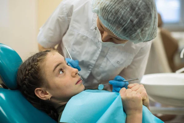 歯医者女性行います歯検査の女の子見ますともに恐怖でザ 歯医者で椅子に座って — ストック写真