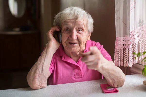 Starší Žena Mluvit Mobilním Telefonu Sedí Stolu Jeho Domě — Stock fotografie