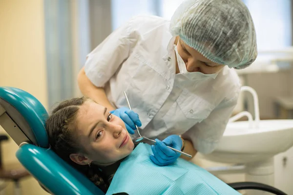 牙科医生检查小女孩的牙齿时 害怕地坐在诊所的牙椅上 — 图库照片