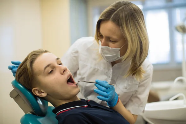 歯医者の椅子で男の歯の検査をする歯科医の女性 ヘルスケアと生活習慣医学の概念 — ストック写真