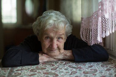 Yalnız beyaz saçlı yaşlı kadının portresi..