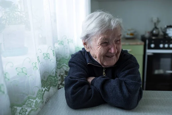 年配の女性はテーブルに座って笑う 高齢者 年金受給者 — ストック写真