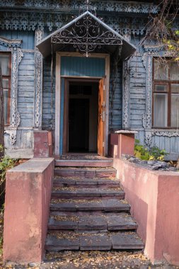 Ahşap bir kır evinin verandasında oyulmuş mimarlar var. Rusya.