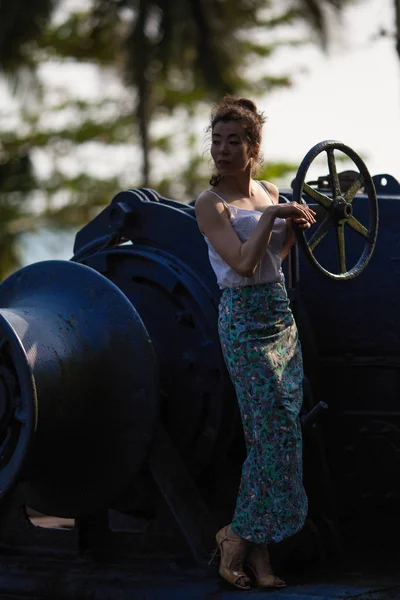 Asian woman in abandoned giant ship in jungle (posing for a photoshoot)