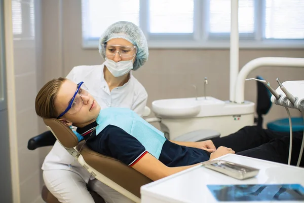女性歯科医とともに患者男肖像画で歯科室 — ストック写真