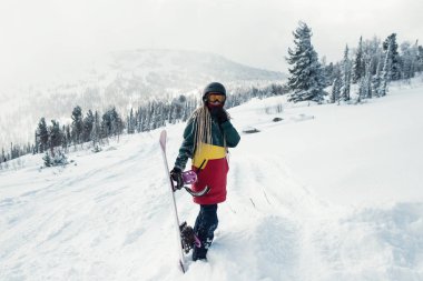 Karlı bir yamaç üzerinde dağlarda snowboard ile Kadın snowboard.