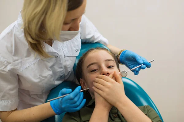 女歯医者あります歯医者あります小さな女の子の検査を心配そうに見えます恐怖と口を閉じますとともに手コキでザ歯科椅子 — ストック写真