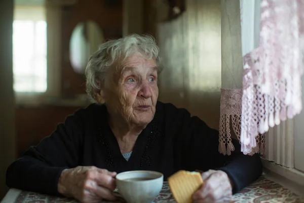 Stará Žena Pije Čaj Sušenkami Něj Doma — Stock fotografie