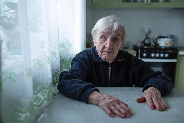 Samotna Starsza Kobieta Siedząca Przy Oknie Jego Domu — Zdjęcie stockowe
