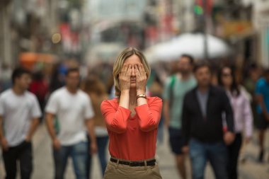 Panic attack in public place - woman covers his eyes.   clipart