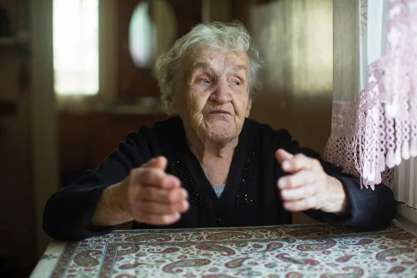 Συναισθηματική Ηλικιωμένη Γυναίκα Λέει Gesturing Κάθεται Ένα Τραπέζι — Φωτογραφία Αρχείου