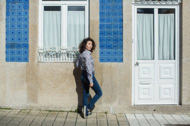 Portekiz, Porto 'da, eski şehir merkezinde, melez bir kadın sokakta poz veriyor..