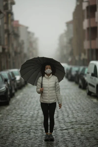 Pandemia Kobieta Rasy Mieszanej Masce Przeciwwirusowej Stoi Ulicy Pochmurną Pogodę — Zdjęcie stockowe