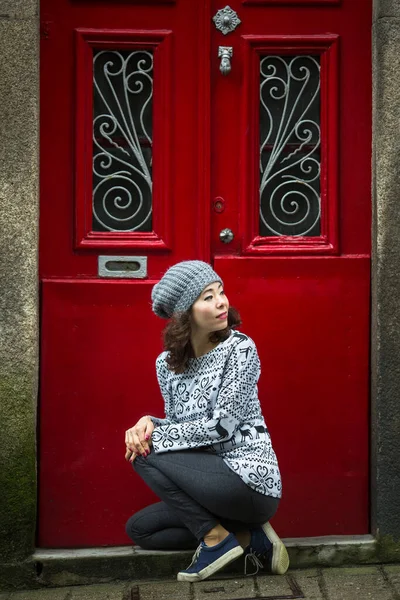 Молодая Женщина Смешанной Расы Позирует Возле Красной Двери Дома Старом — стоковое фото