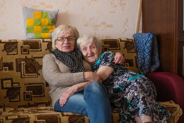 Una Vecchia Donna Con Figlia Adulta Che Coccola Sul Divano — Foto Stock