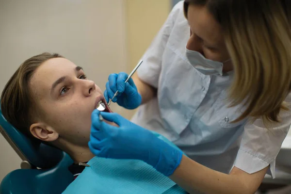 歯の椅子で男の歯の検査をする歯科医の女性 血液学医学の概念 — ストック写真