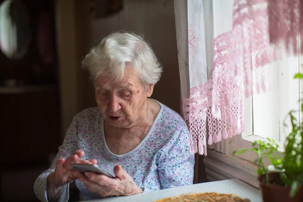 Μια Ηλικιωμένη Γυναίκα Ένα Smartphone Στα Χέρια Της — Φωτογραφία Αρχείου