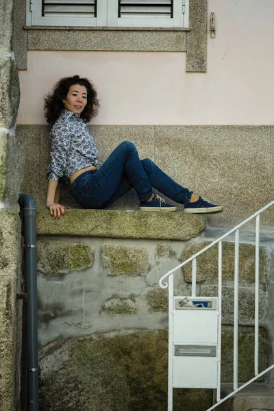 Wielokulturowa Kobieta Siedząca Przy Ścianie Domu Porto Portugalia — Zdjęcie stockowe