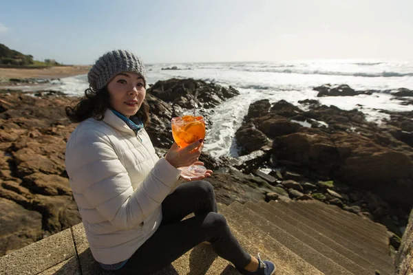 Misto Razza Asiatico Donna Seduta Con Cocktail Fondo Oceano Rocce — Foto Stock