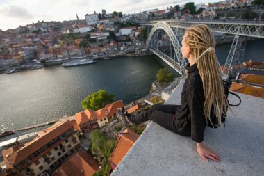 Sarışın kadın Dom Luis I Bridge, Porto, Portekiz 'in karşısında oturuyor..