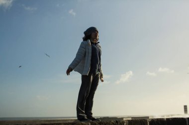 Atlantik gezinti güvertesinde duran melez genç bir kadın..