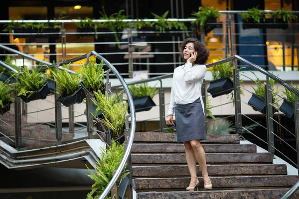 Young Mixed Race Woman Talking Mobile Standing Steps Business Center — Stock Photo, Image