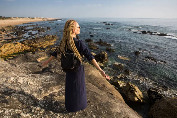 大西洋の岩場の海岸にいる若いブロンドの女性 — ストック写真