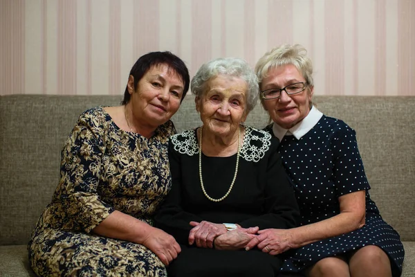 Una Anciana Posa Con Dos Hijas Adultas Sentadas Sofá — Foto de Stock