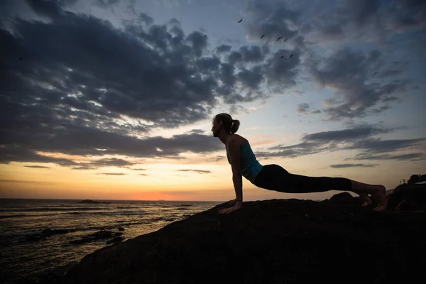 ヨガの女性は夕暮れ時に海岸で練習をしています ポルトガル — ストック写真