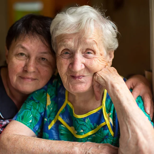 Portrait of a old woman with adult daughter.