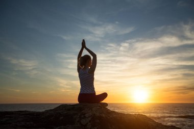 Gün batımında Lotus 'ta yoga yapan kadın meditasyonu silueti..