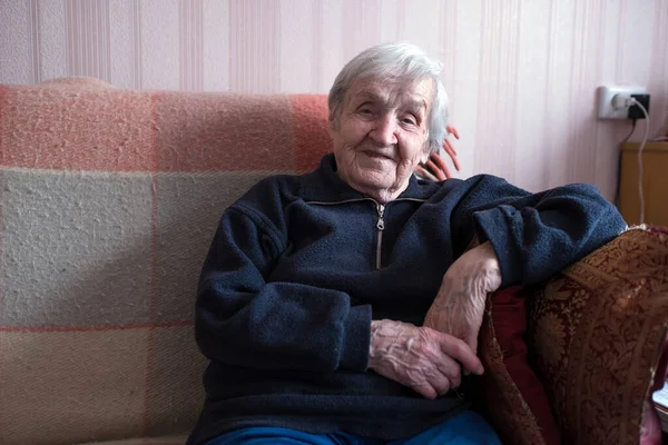 Μια Γριά Γυναίκα Κάθεται Στον Καναπέ Στο Σπίτι Της — Φωτογραφία Αρχείου