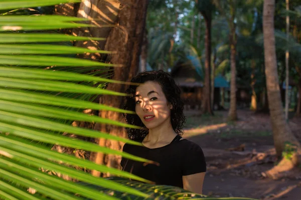 Gemengd Ras Aziatische Vrouw Kijkt Door Palmbladeren — Stockfoto