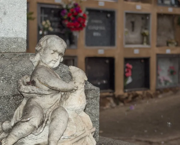 Statue of a child angel made of stone in the cemetery