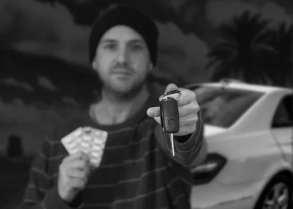 ilaç tüketmek için arabanın anahtarları veren kişi