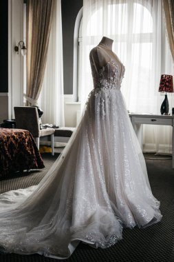 Otel odasında manken üzerinde gelinlik.