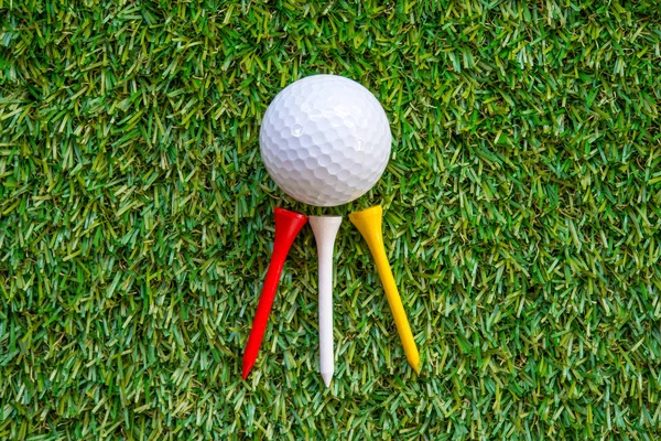 Golfbal en tee op gras — Stockfoto