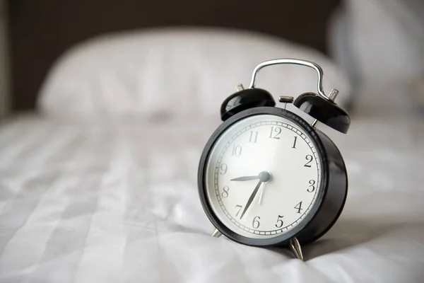 Relógio despertador na cama — Fotografia de Stock