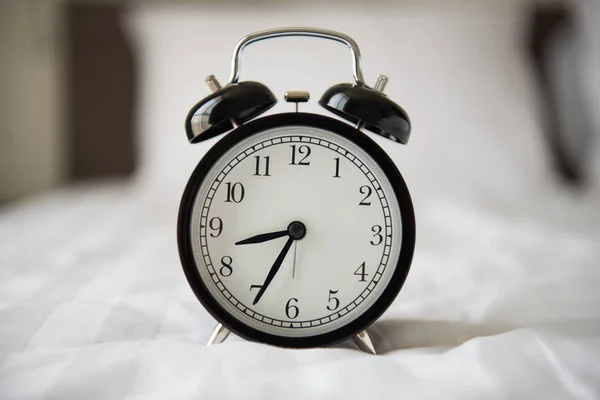 Relógio despertador na cama — Fotografia de Stock