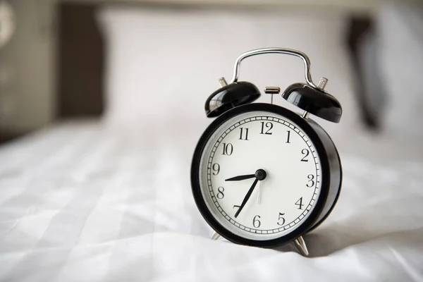 Alarm clock on bed Royalty Free Stock Photos
