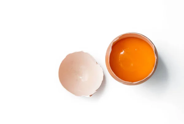 Egg yolk in egg shell, cracked egg white isolated on white backg — Stock Photo, Image